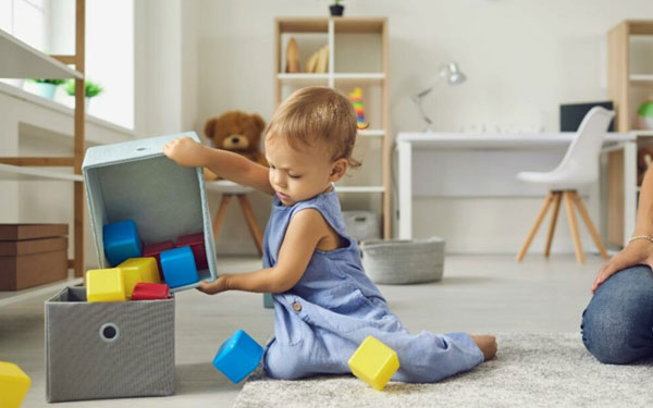Child practicing pouring exercises as part of a practical life activity.